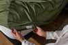 Woman holding sova tag that is olive green