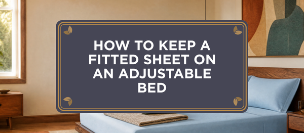 Mid-century modern bedroom in bright morning light with a bed dressed in Light Blue The One Sheet connected organic bamboo viscose sheets, under a charcoal Sova crest reading How to Keep a Fitted Sheet on an Adjustable Bed.